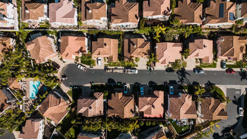 Photo by Kelly Aerial photograph showcasing a suburban neighborhood in Costa Mesa, CA, with neatly arranged houses and streets.