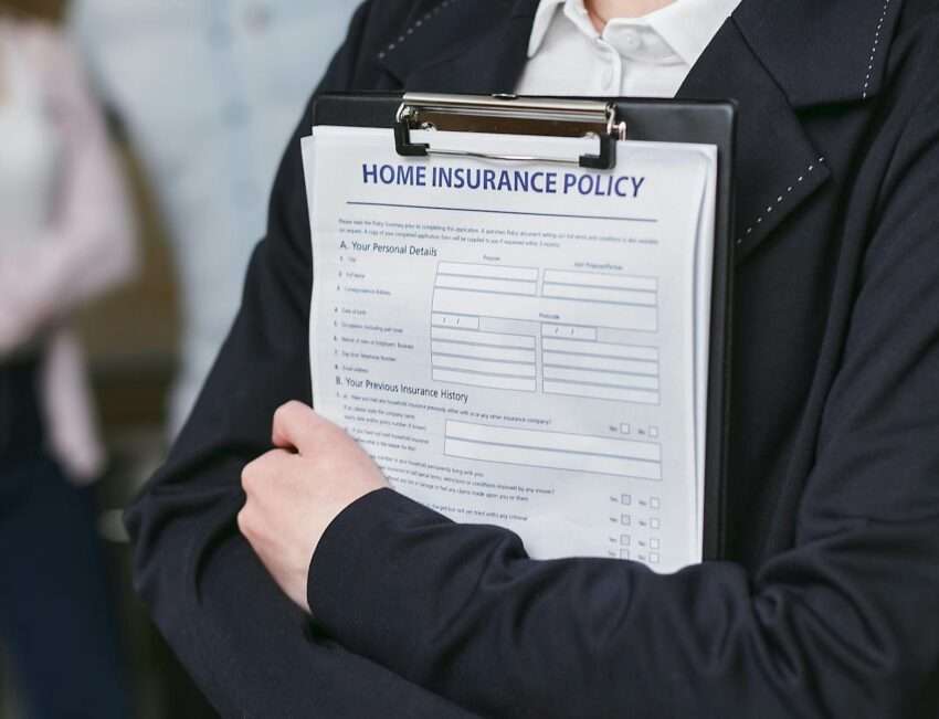 Photo by Mikhail Nilov Close-up of a person holding a home insurance policy on a clipboard, captured indoors.