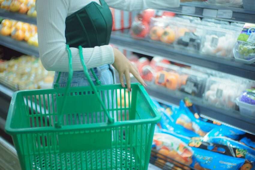 Photo by Jeremiah Lazo a woman holding a shopping basket in a grocery store